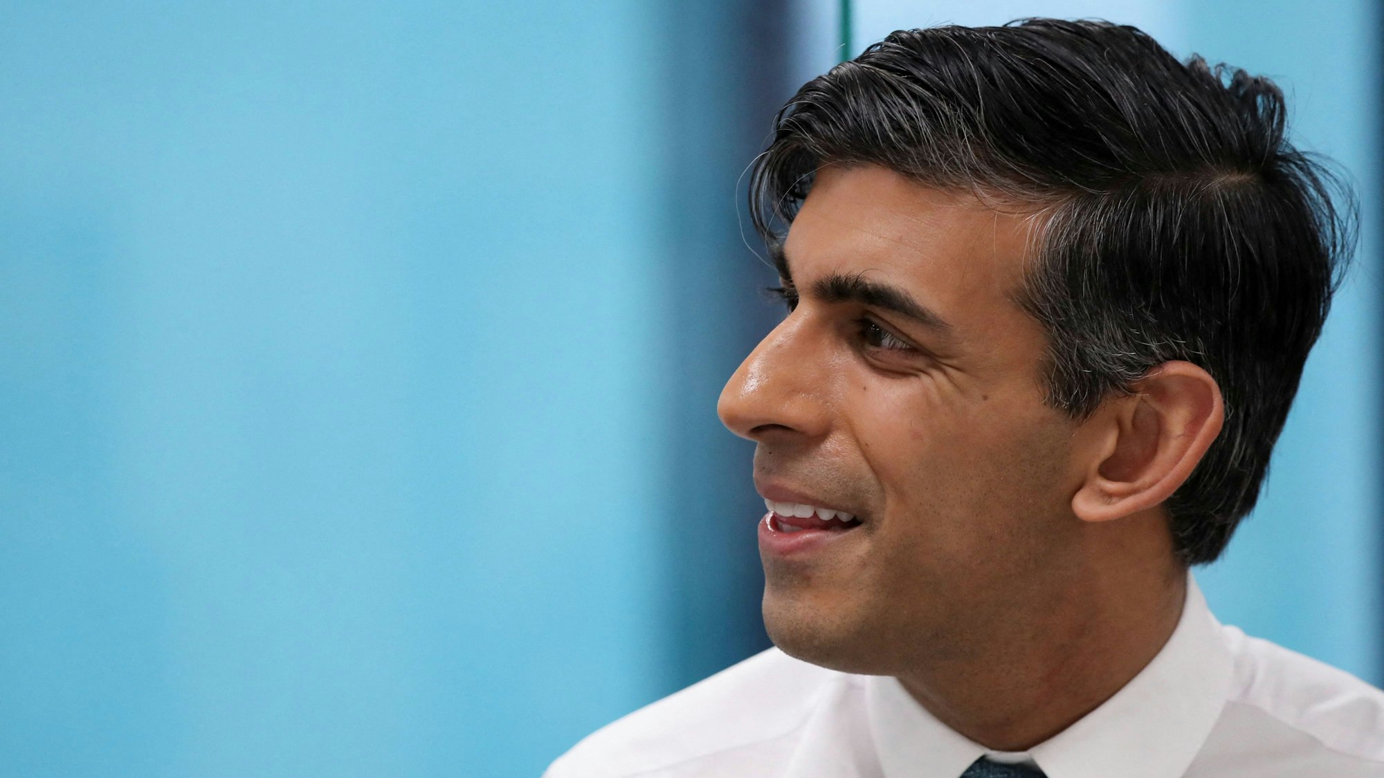 Es ist Rishi Sunak zu sehen, vor einem blauen Hintergrund.