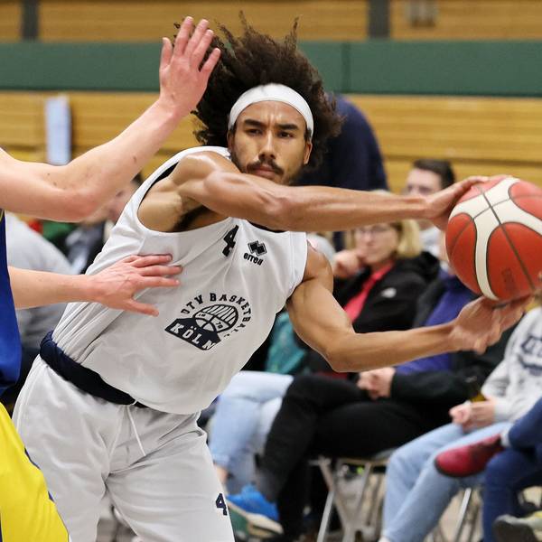 Ein Basketballspieler passt an seinem Gegenspieler vorbei.