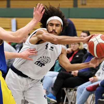 Ein Basketballspieler passt an seinem Gegenspieler vorbei.