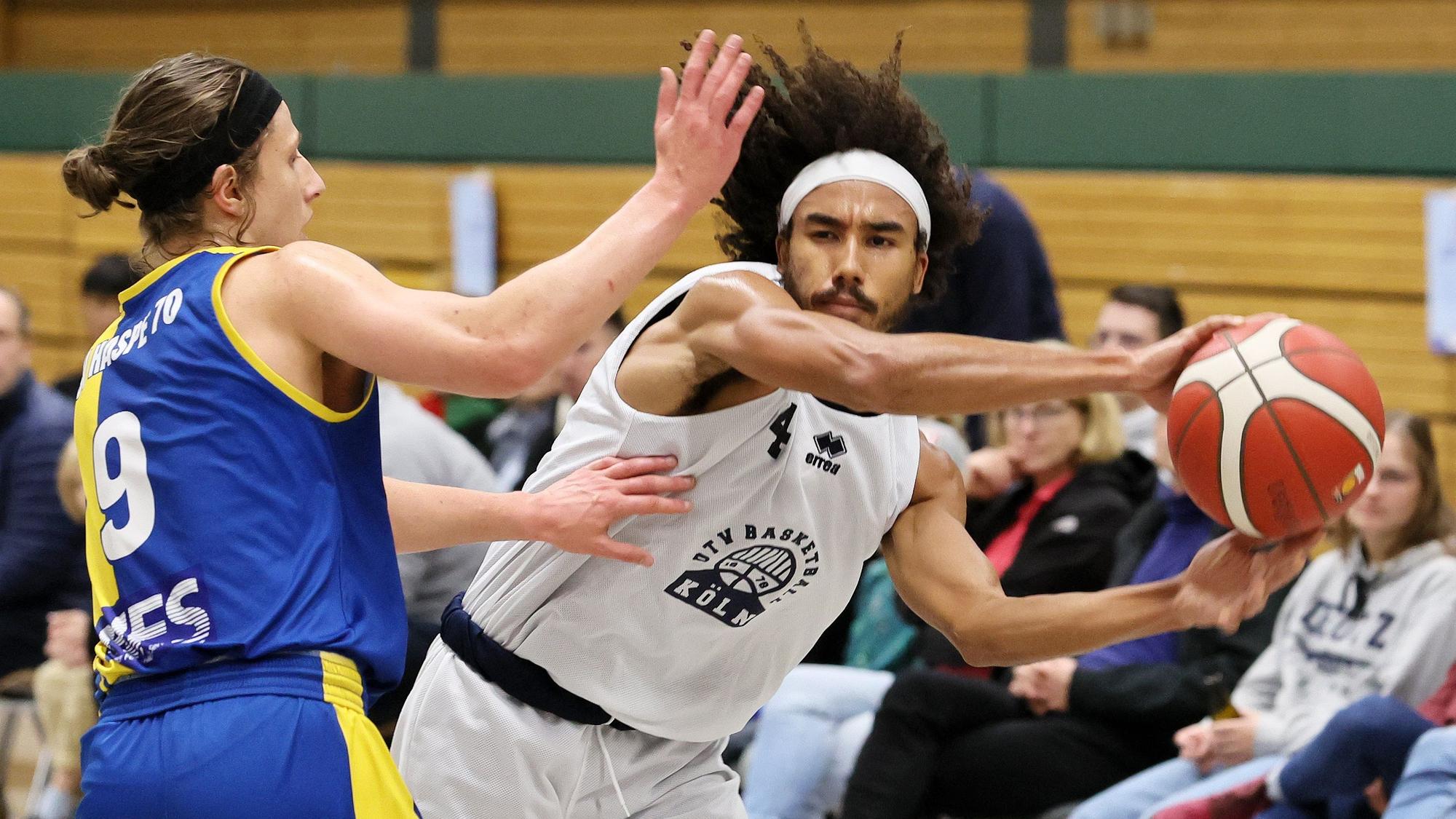 Ein Basketballspieler passt an seinem Gegenspieler vorbei.