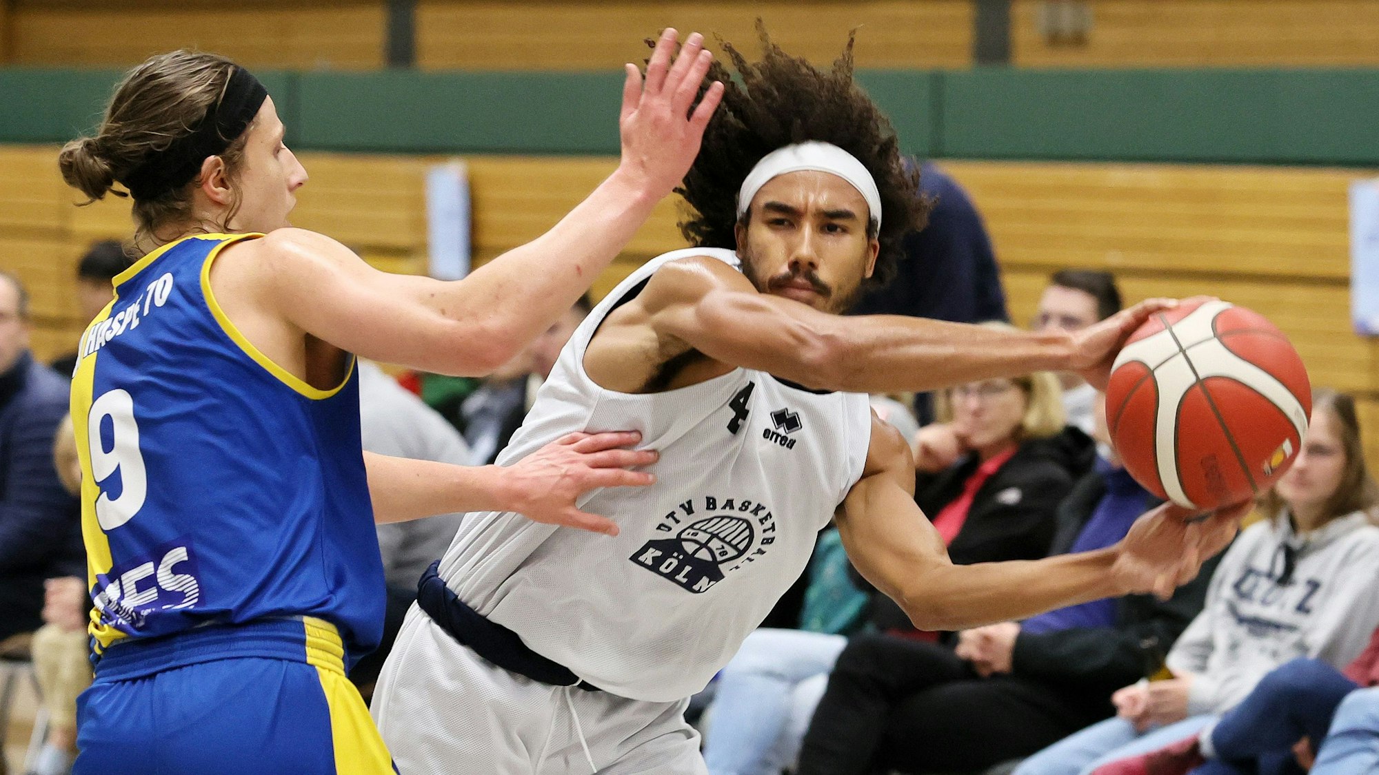 Ein Basketballspieler passt an seinem Gegenspieler vorbei.