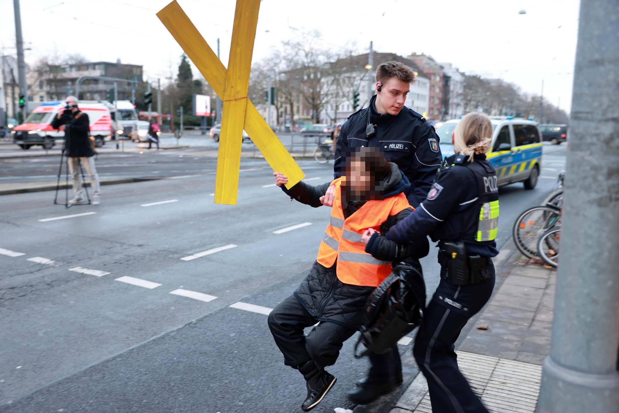 Eine Klima-Aktivistin der „Letzten Generation“ wird von der Straße getragen.