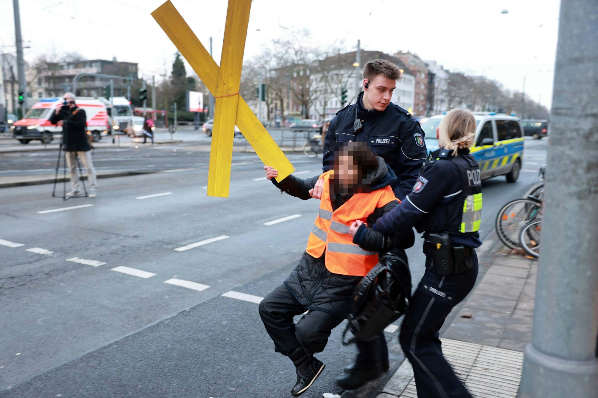 Eine Klima-Aktivistin der „Letzten Generation“ wird von der Straße getragen.