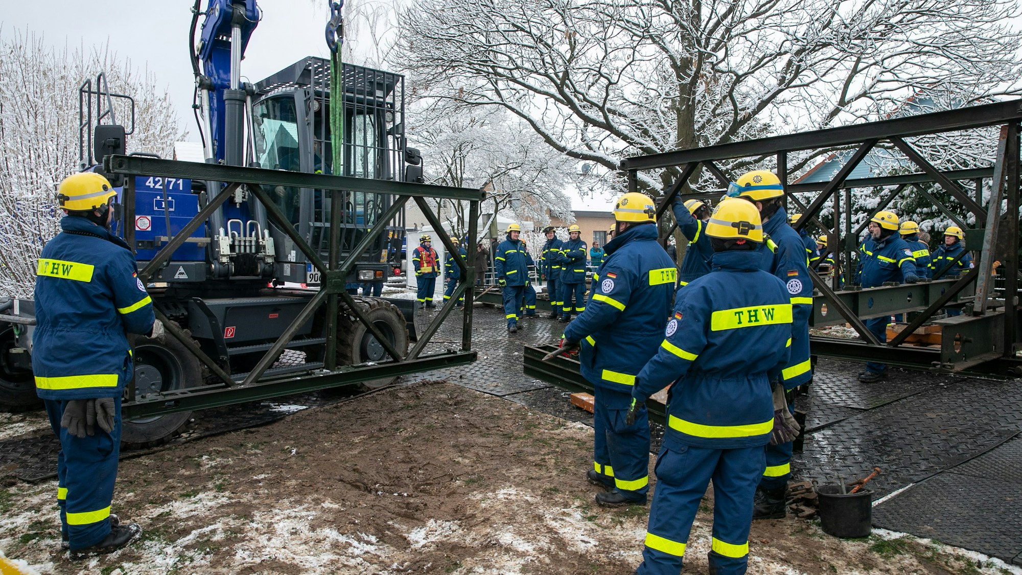 Mit einem THW-Bagger wurden die einzelnen Seitenteile der Behelfsbrücke über die Swist in der Heimerzheimer Quellenstraße transportiert. Foto: Volker Jost