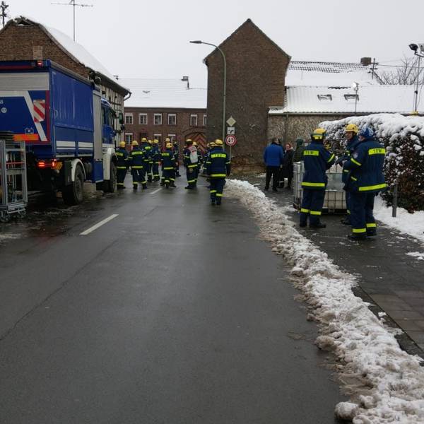 Einsatzkräfte des THW stehen auf der Straße und bereiten ihren Einsatz vor.
