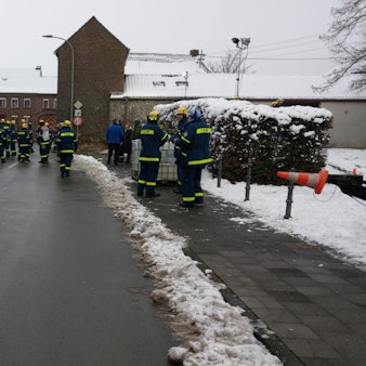 Einsatzkräfte des THW stehen auf der Straße und bereiten ihren Einsatz vor.