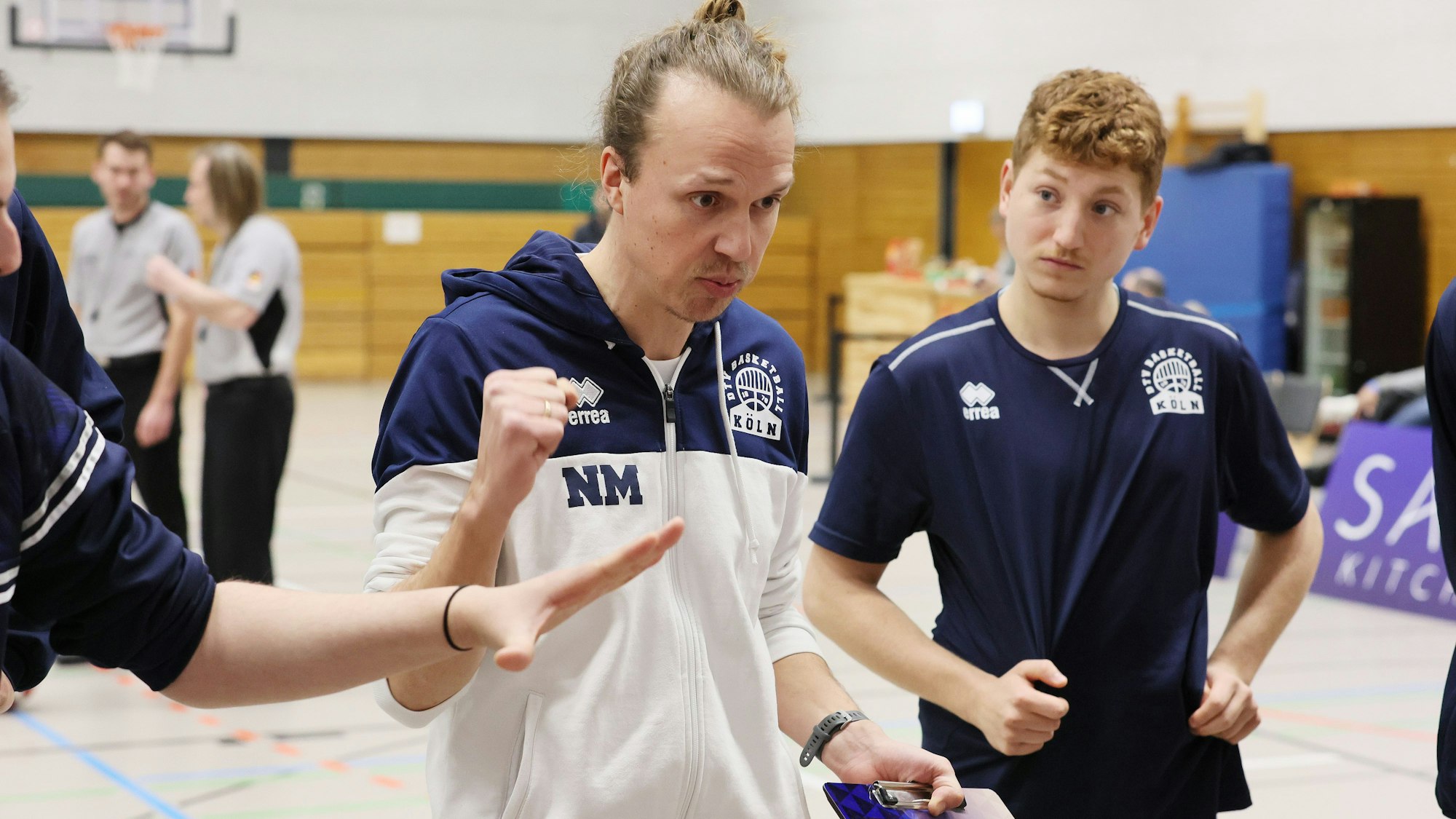 Ein Basketballtrainer bespricht sich mit seinem Team während einer Auszeit.