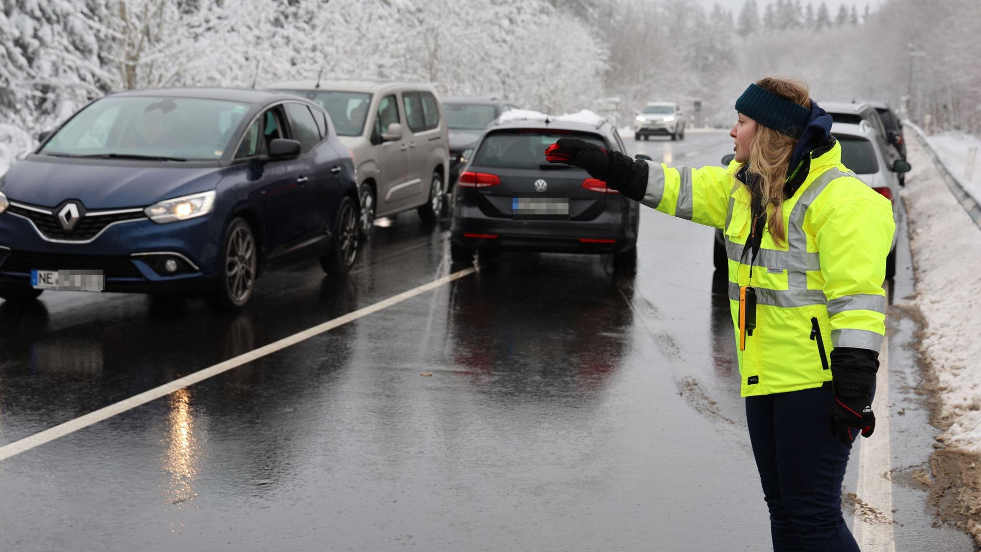 Eine Mitarbeiterin des Ordnungsamts der Gemeinde Hellenthal weist Autofahrer ein.