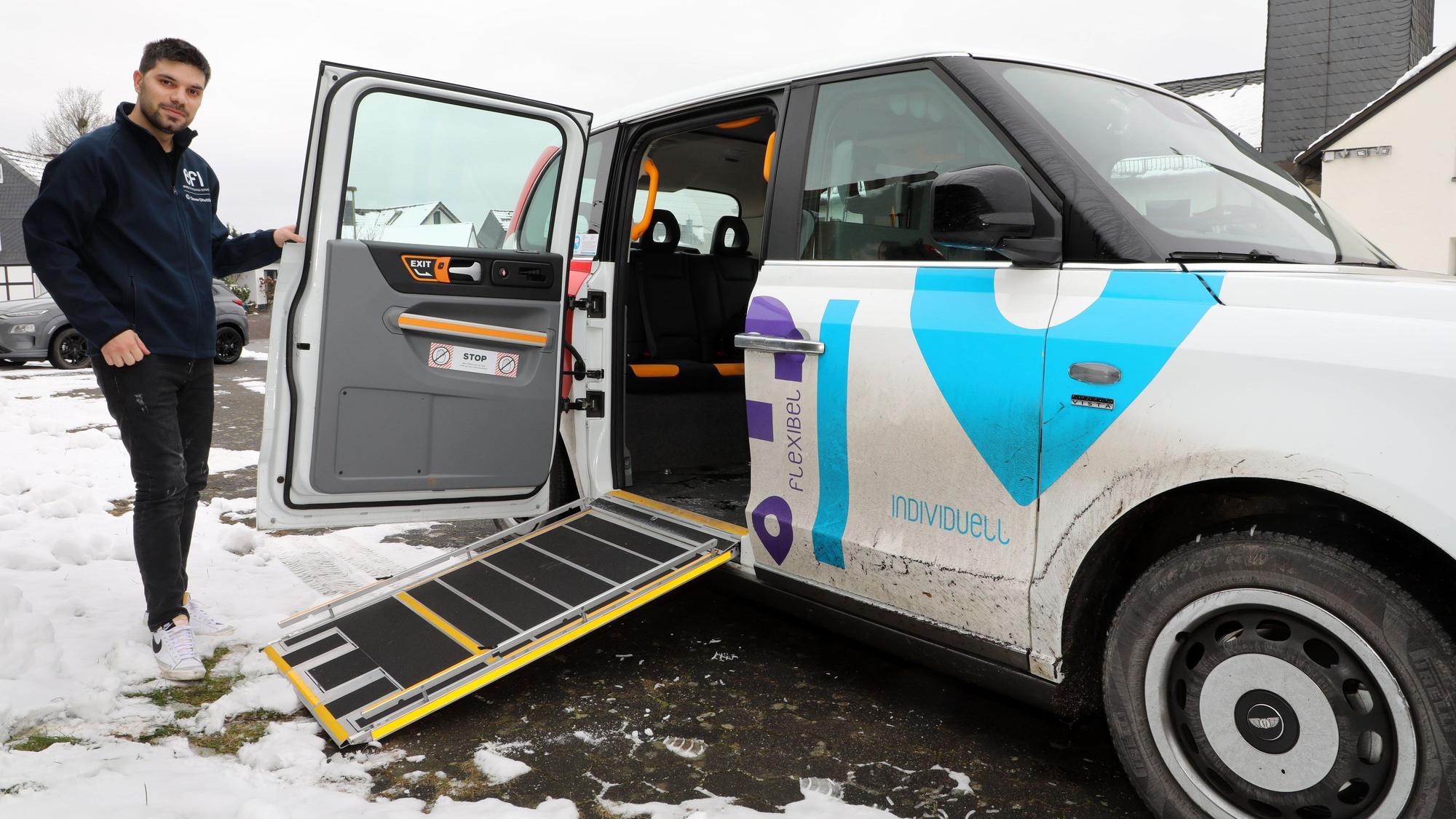 Fahrer Sercan Önen steht neben einem „Efi“-Auf-Abruf-Taxi mit ausgefahrener Rampe.