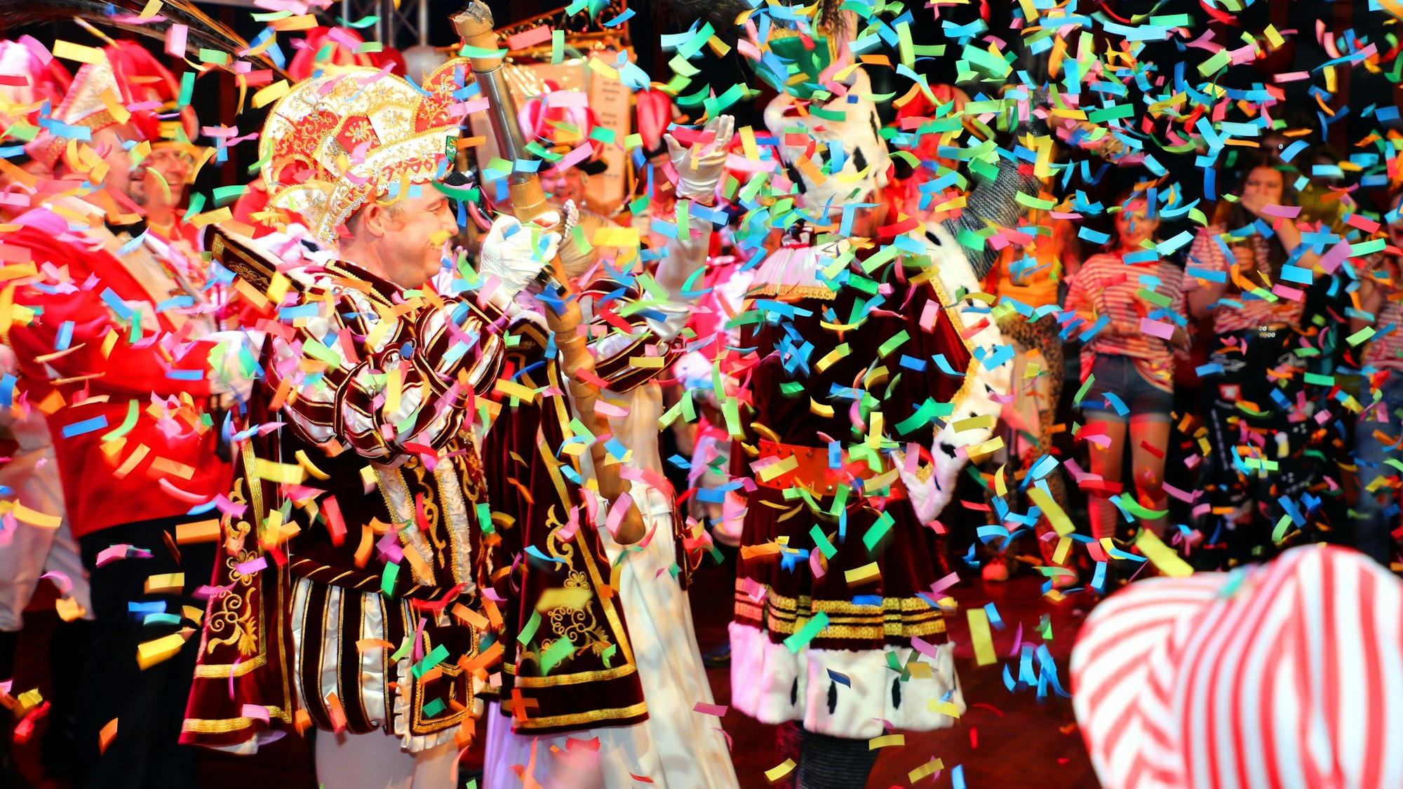 Das Dreigestirn ist durch Konfetti-Regen nur ungefähr zu erahnen.