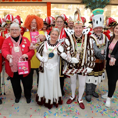 Das Dreigestirn und andere Karnevalisten haben sich zu einem Gruppenbild aufgestellt.