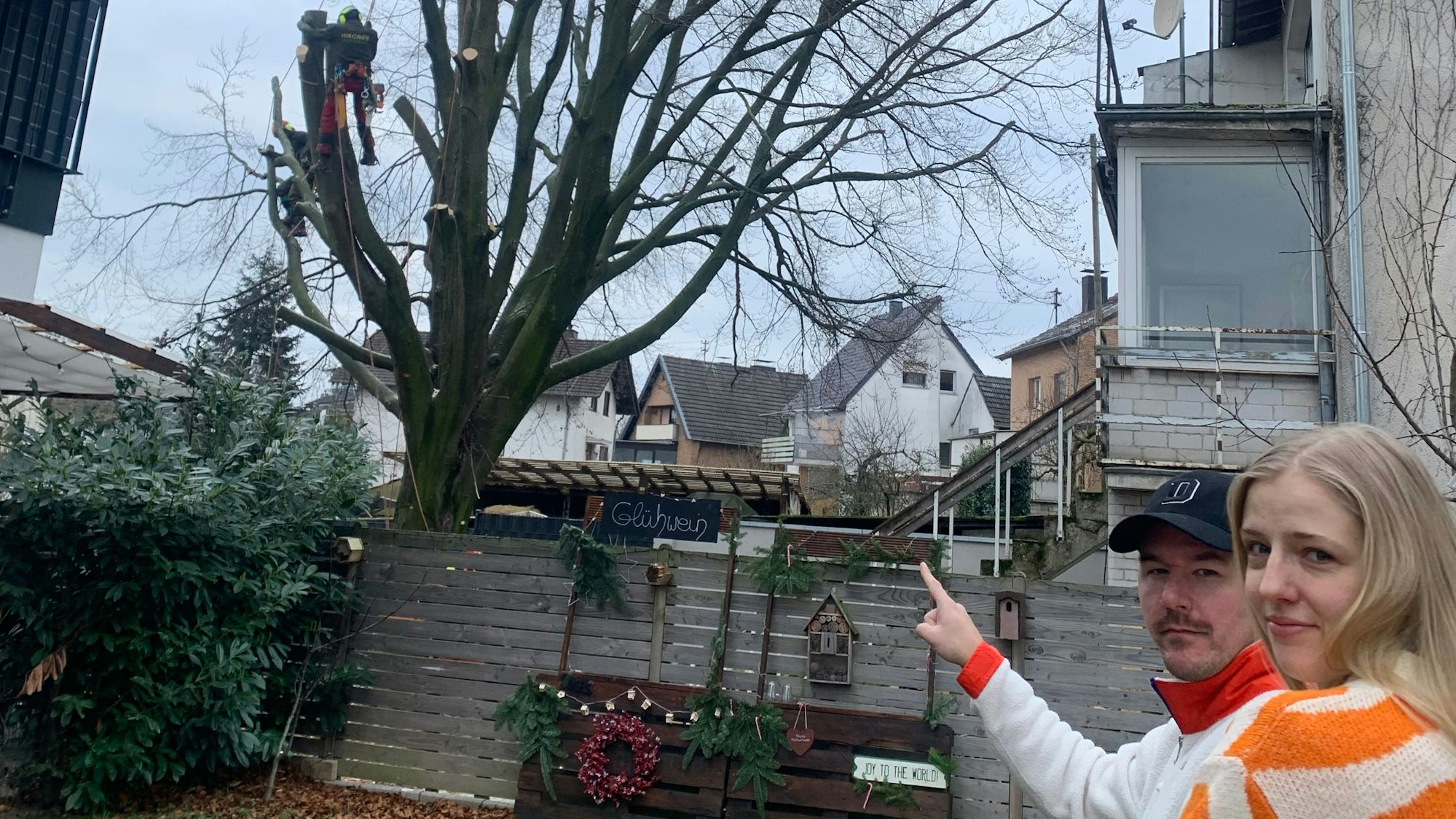 Pierre und Nora Dresen zeigen auf die 80 Jahre alte Buche auf dem Nachbargrundstück, während diese gefällt wird.
