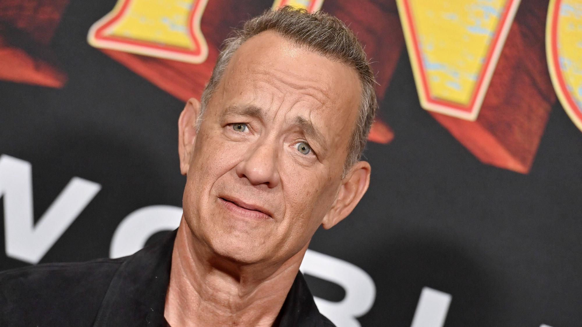 Tom Hanks vor einem Plakat von „Pinocchio“.