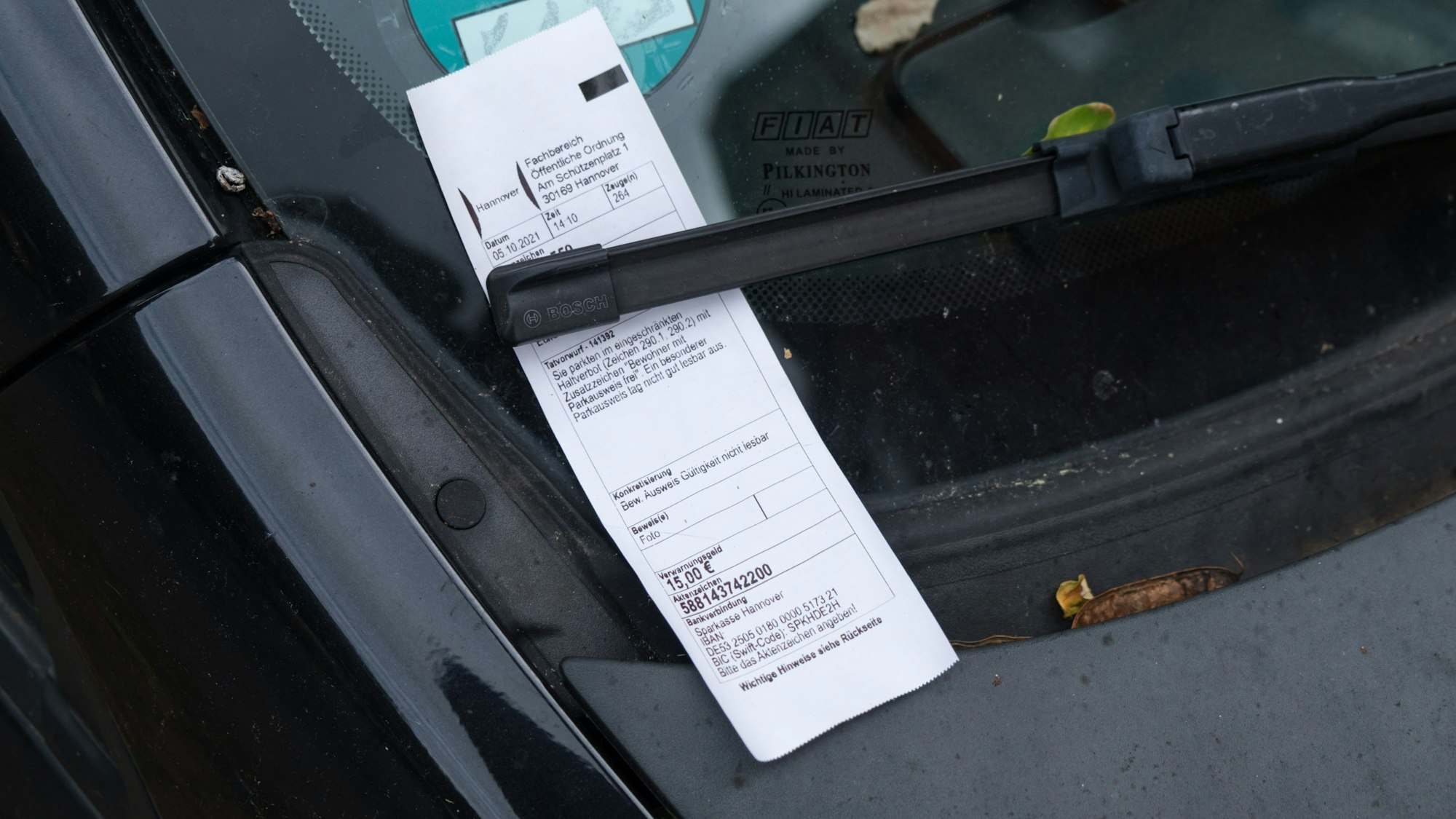 Ein Strafzettel, hier in Hannover, klemmt hinter einem Scheibenwischer.
