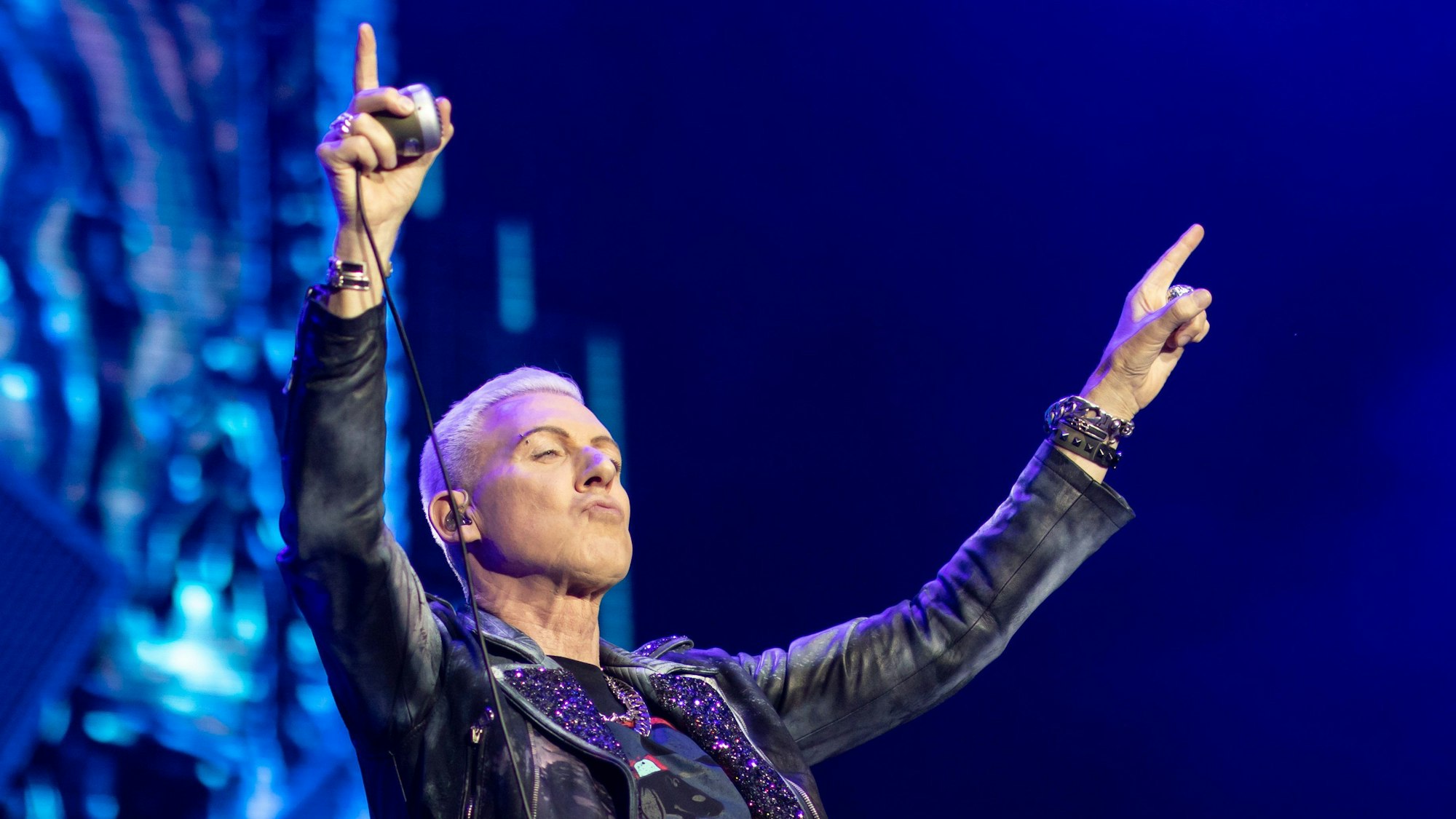 Der Sänger der deutschen Techno-Band Scooter, H.P. Baxxter (Hans Peter Geerdes), steht auf der Bühne und hebt die Arme