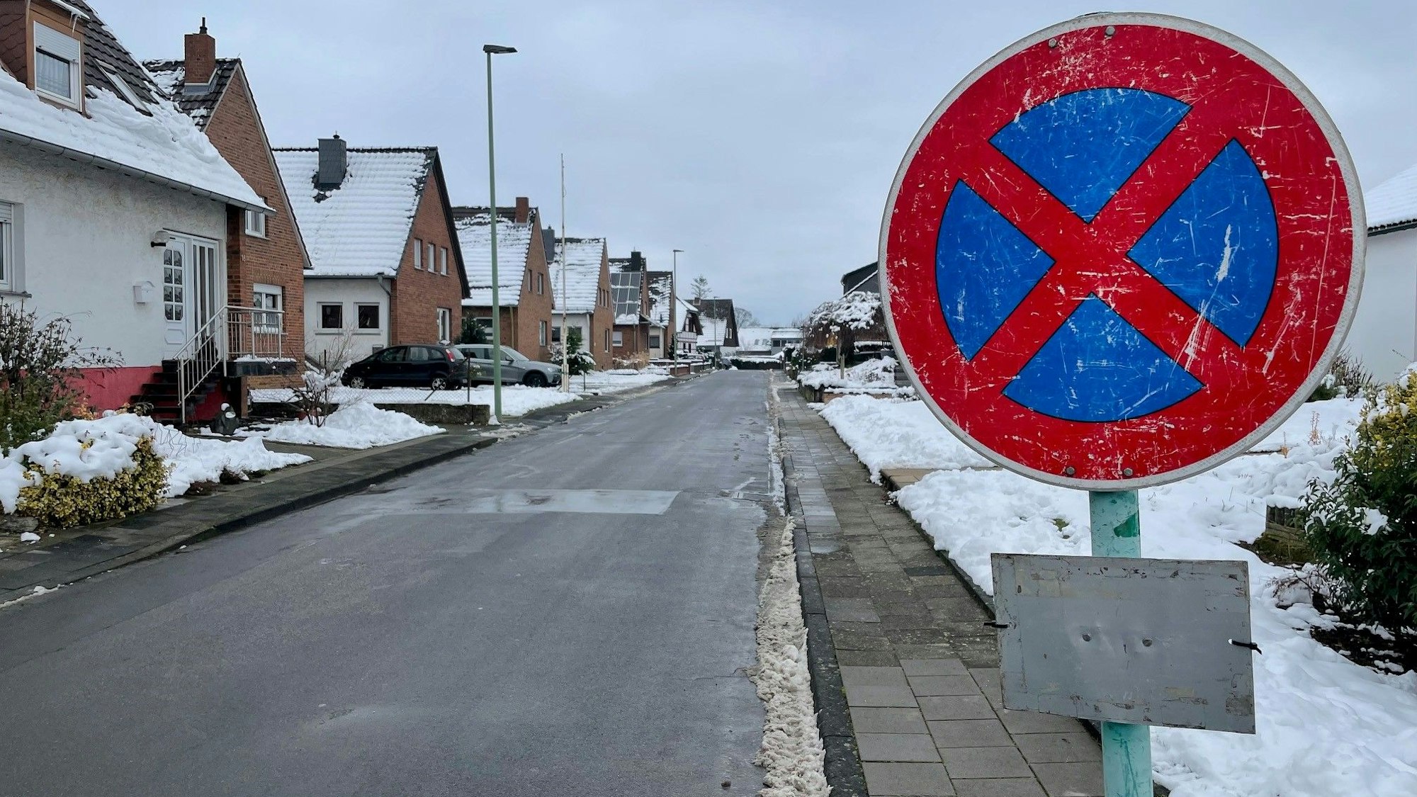 Ein Halteverbotsschild steht auf einem Bürgersteig. Die Stadt hat die Schilder aufgestellt, weil ein Haus droht einzustürzen.