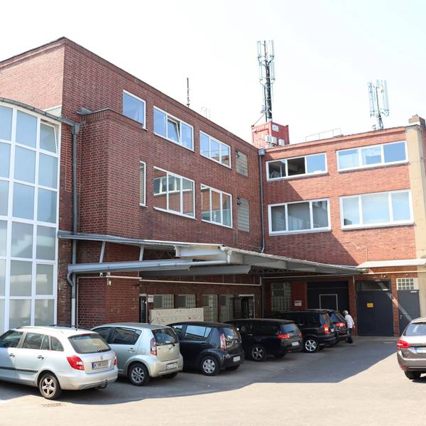 Das Atelierhaus von außen mit davorstehenden Autos.