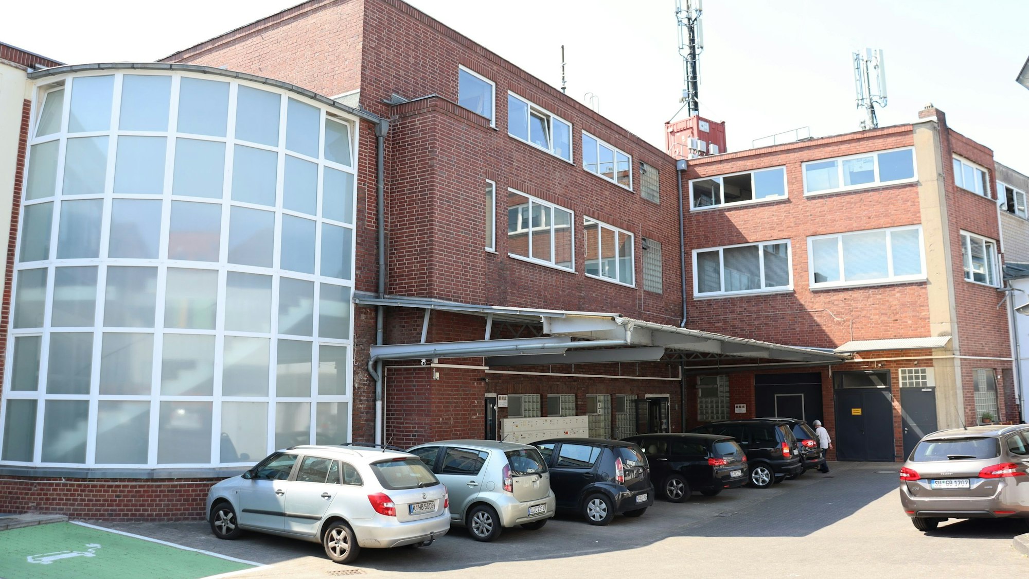 Das Atelierhaus von außen mit davorstehenden Autos.