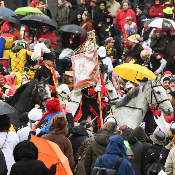 Eine Gruppe zu Pferd reitet beim Rosenmontagszug 2020 in Düsseldorf durch die Menge.