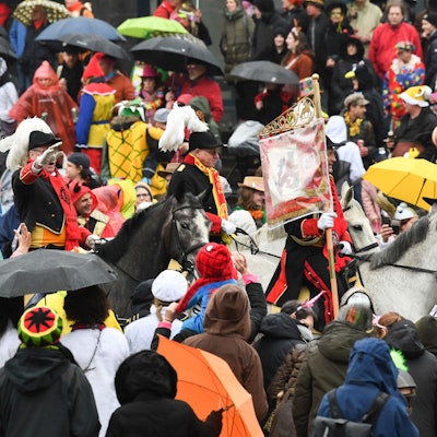 Eine Gruppe zu Pferd reitet beim Rosenmontagszug 2020 in Düsseldorf durch die Menge.