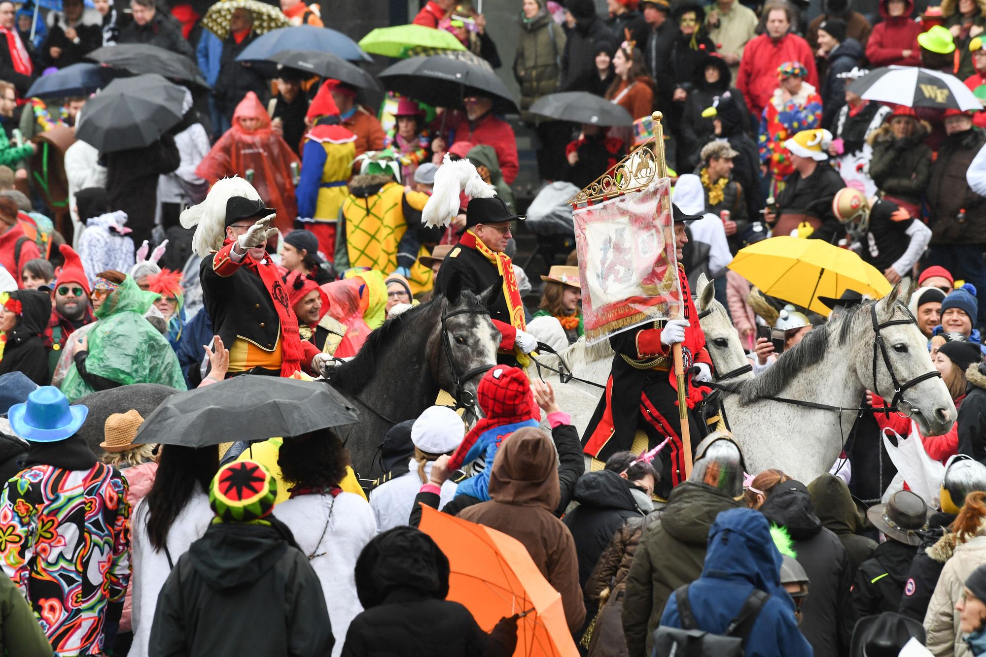 Eine Gruppe zu Pferd reitet beim Rosenmontagszug 2020 in Düsseldorf durch die Menge.
