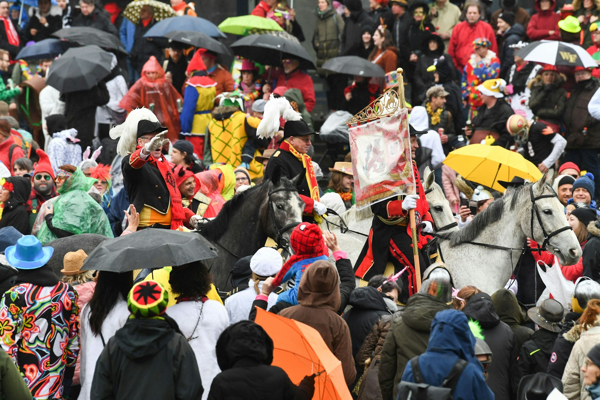 Eine Gruppe zu Pferd reitet beim Rosenmontagszug 2020 in Düsseldorf durch die Menge.