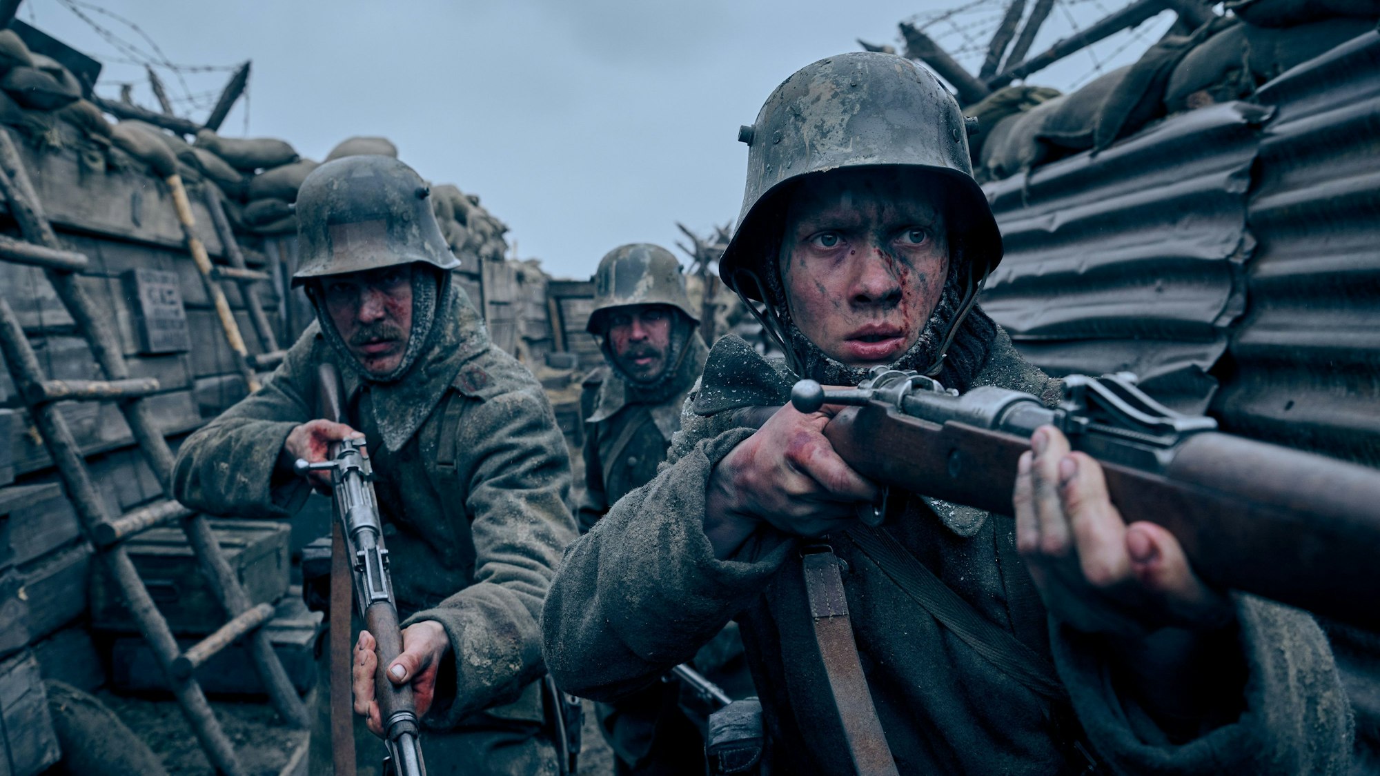 Szene aus „Im Westen nichts Neues“: Felix Kammerer (r) als Paul Bäumer, Albrecht Schuch (l) als Stanislaus Katczinsky und Edin Hasanovic als Tjaden Stackfleet in einem Schützengraben.