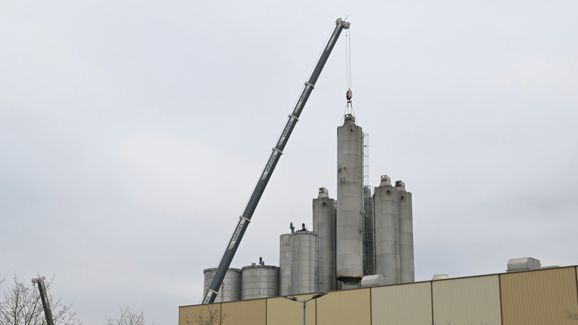 Ein Kram hebt die großen Zanders-Silos vom Gelände.