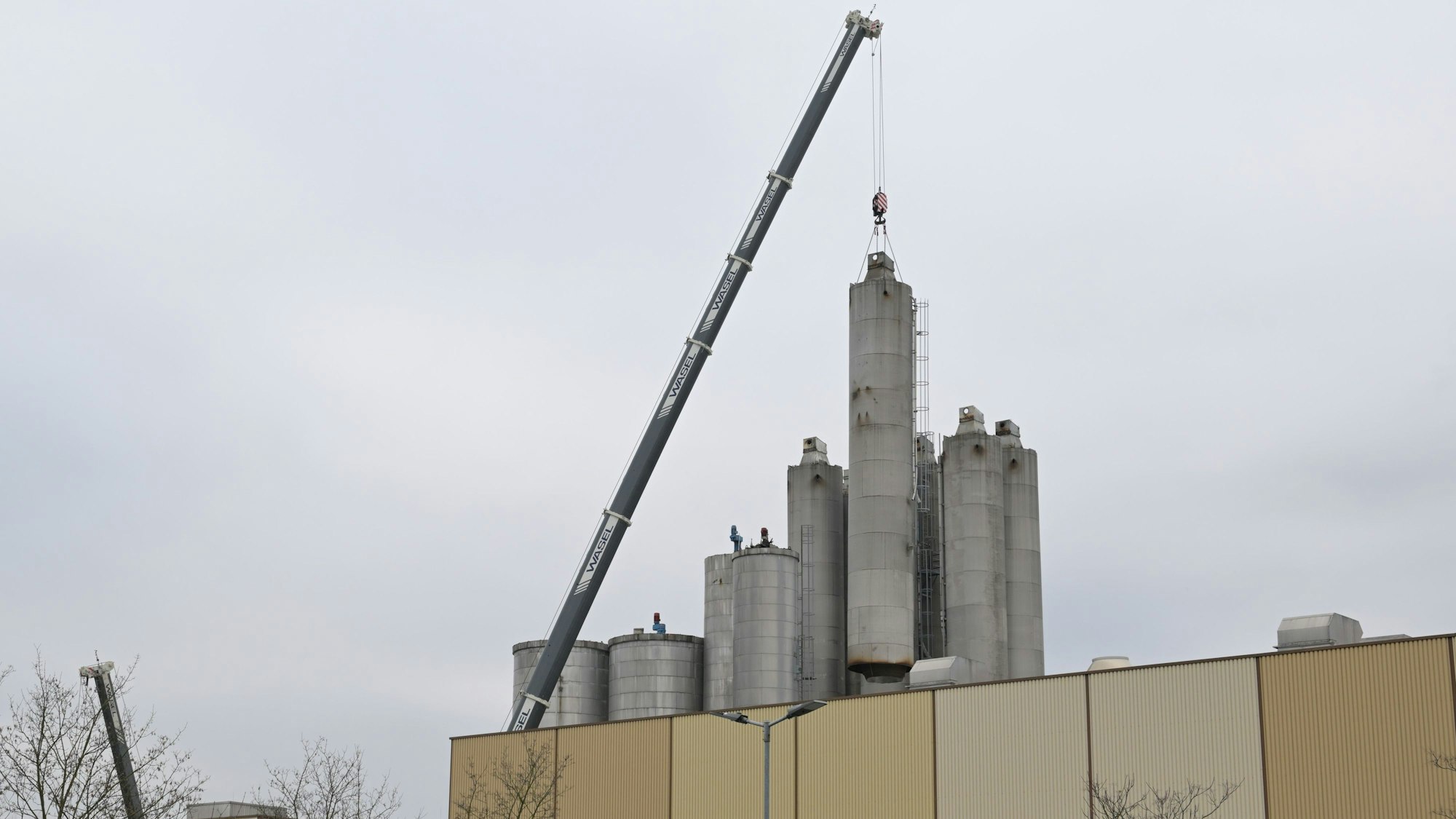Kräne heben die Silos vom ehemaligen Zanders-Gelände in Bergisch Gladbach.