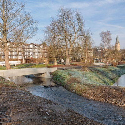 Blick auf die Wiehl und die Stadt im Hintergrund des Wassers.