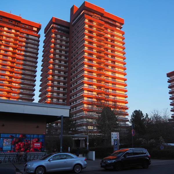 Hochhäuser im Wohnpark Bayenthal mit blauem Himmel und Sonne.