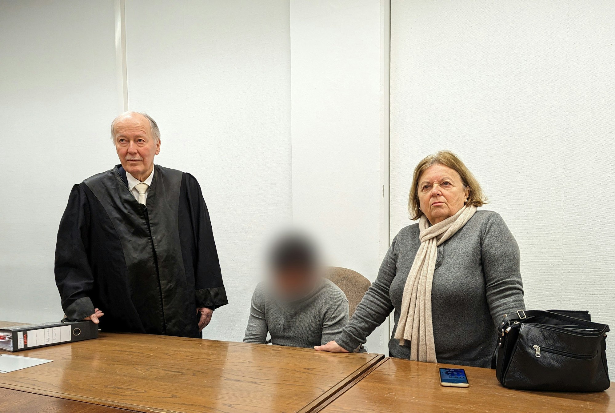 25.01.2023, Nordrhein-Westfalen, Köln: Der angeklagte 30-Jährige (M), sein Anwalt Klaus Kirchner, und eine Dolmetscherin stehen im Kölner Amtsgericht. Der Angeklagte muss sich im Prozess wegen des Einbruchs in ein Haus verantworten, in dem im Januar 2022 des prominente Fernsehen-Paar Pocher lebte.