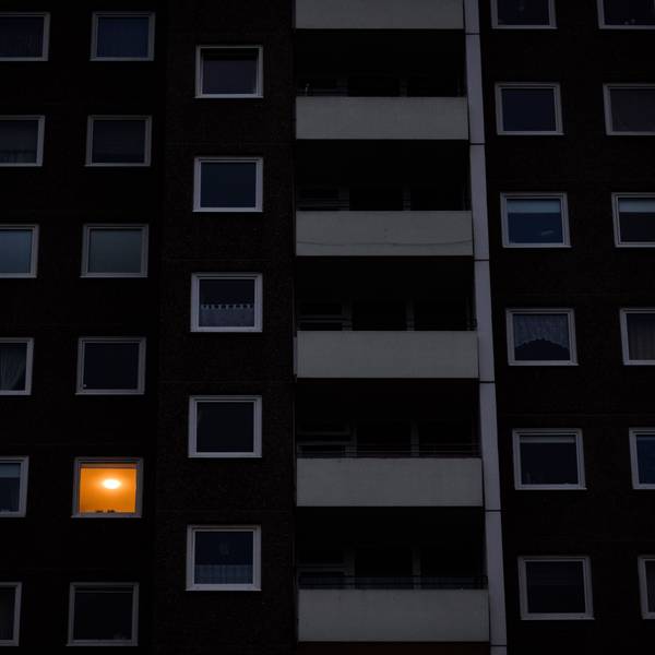 Nur in einer Wohnung eines Mehrfamilienhauses brennt am frühen Morgen Licht. Die teils massiv gestiegenen Preise für Gas und Strom bereiten viele Menschen in Deutschland finanzielle Schwierigkeiten.