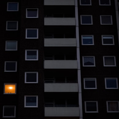 Nur in einer Wohnung eines Mehrfamilienhauses brennt am frühen Morgen Licht. Die teils massiv gestiegenen Preise für Gas und Strom bereiten viele Menschen in Deutschland finanzielle Schwierigkeiten.