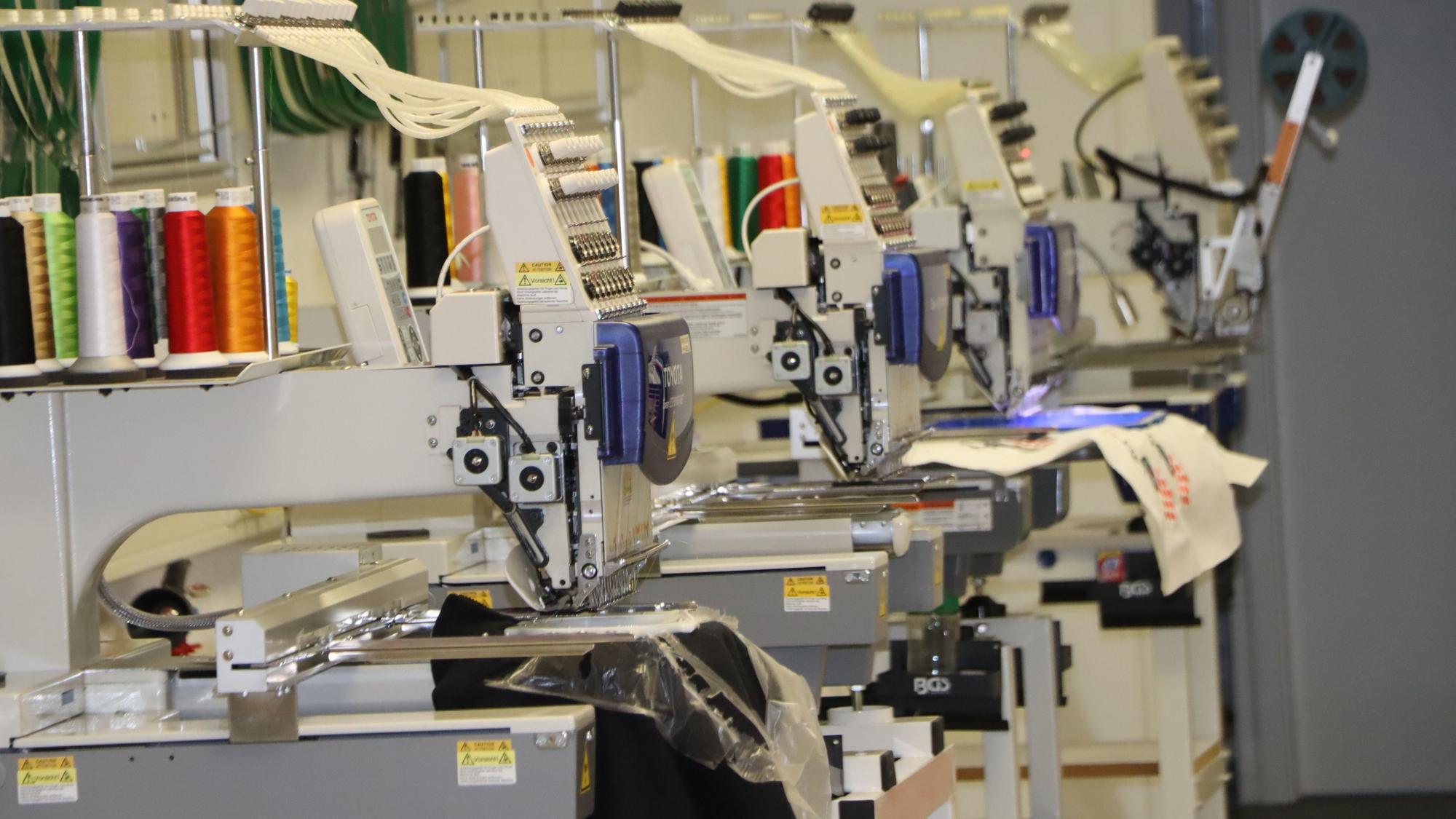 Vier industrielle Stickmaschinen rattern im Atelier in Gleuel.