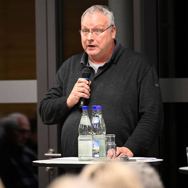 Pfarrer Winfried Kissel spricht in ein Mikrofon.