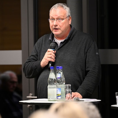 Pfarrer Winfried Kissel spricht in ein Mikrofon.