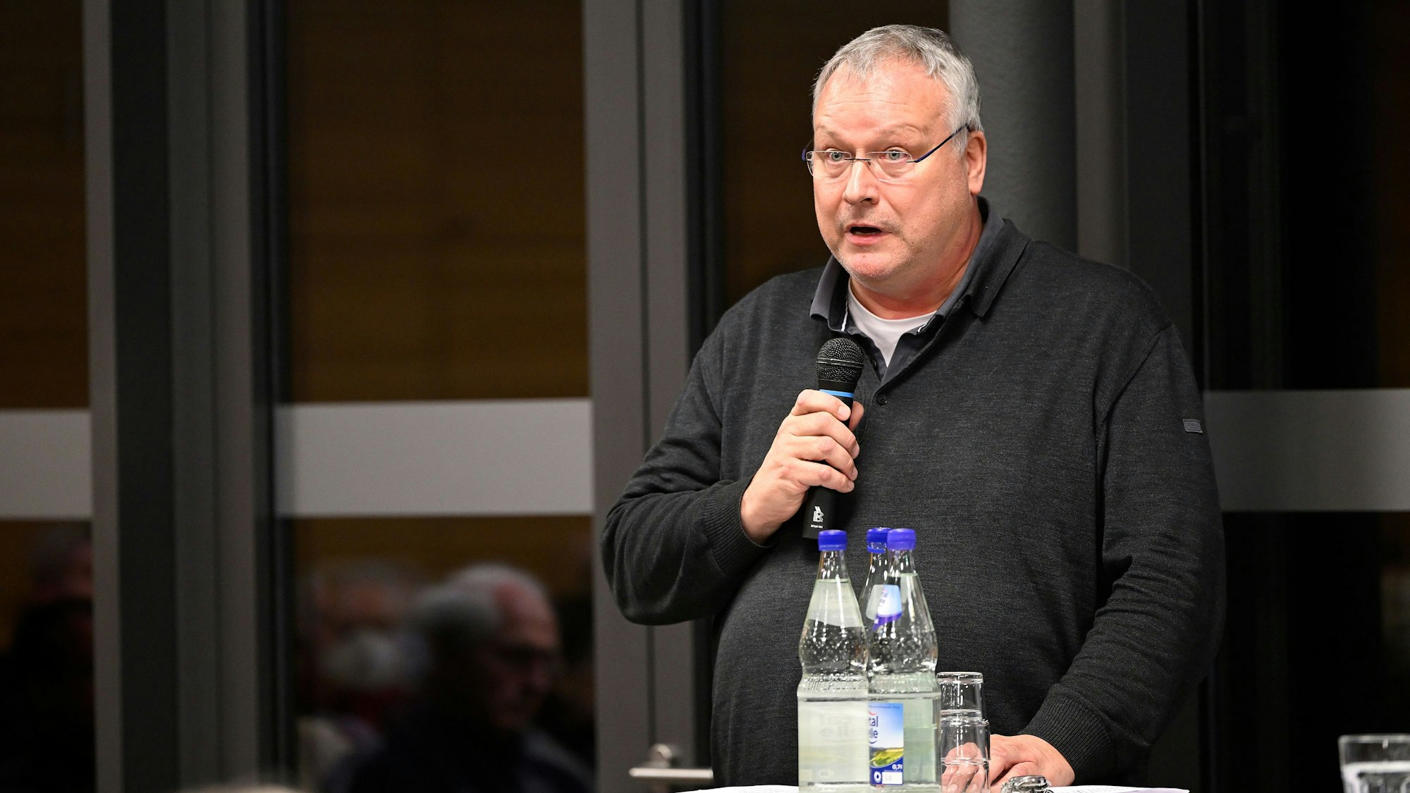 Pfarrer Winfried Kissel spricht in ein Mikrofon.