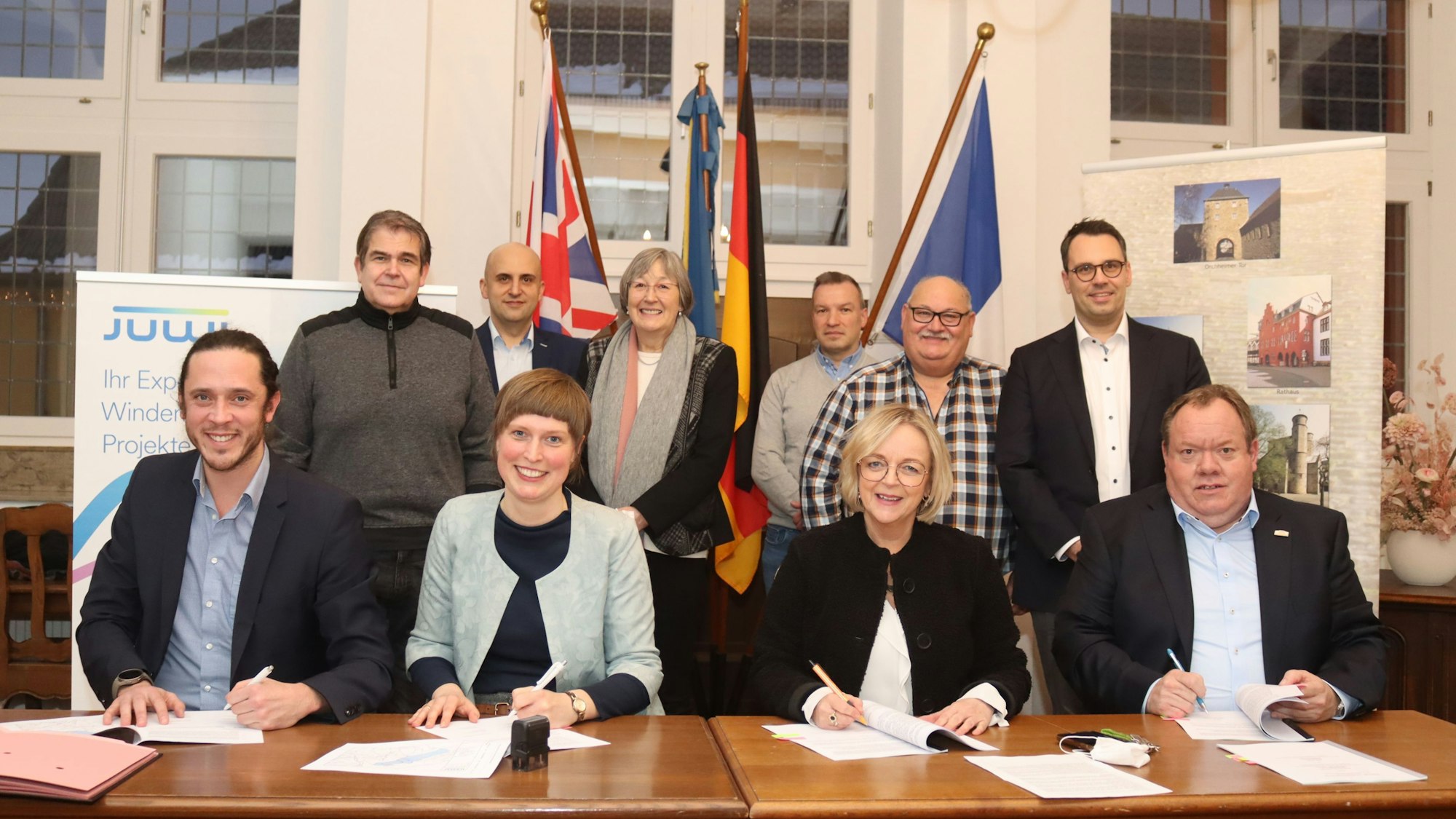 Vertragsunterzeichnung: Auf dem Bild sind (v.l.) Sebastian Brockes (Leiter Akquisition West bei Juwi), Federica Pelzer (Projektleiterin Juwi), Sabine Preiser-Marian (Bürgermeisterin Bad Münstereifel) und Kurt Reidenbach (Kämmerer Bad Münstereifel). Im Hintergrund Vertreter der Ratsfraktionen.