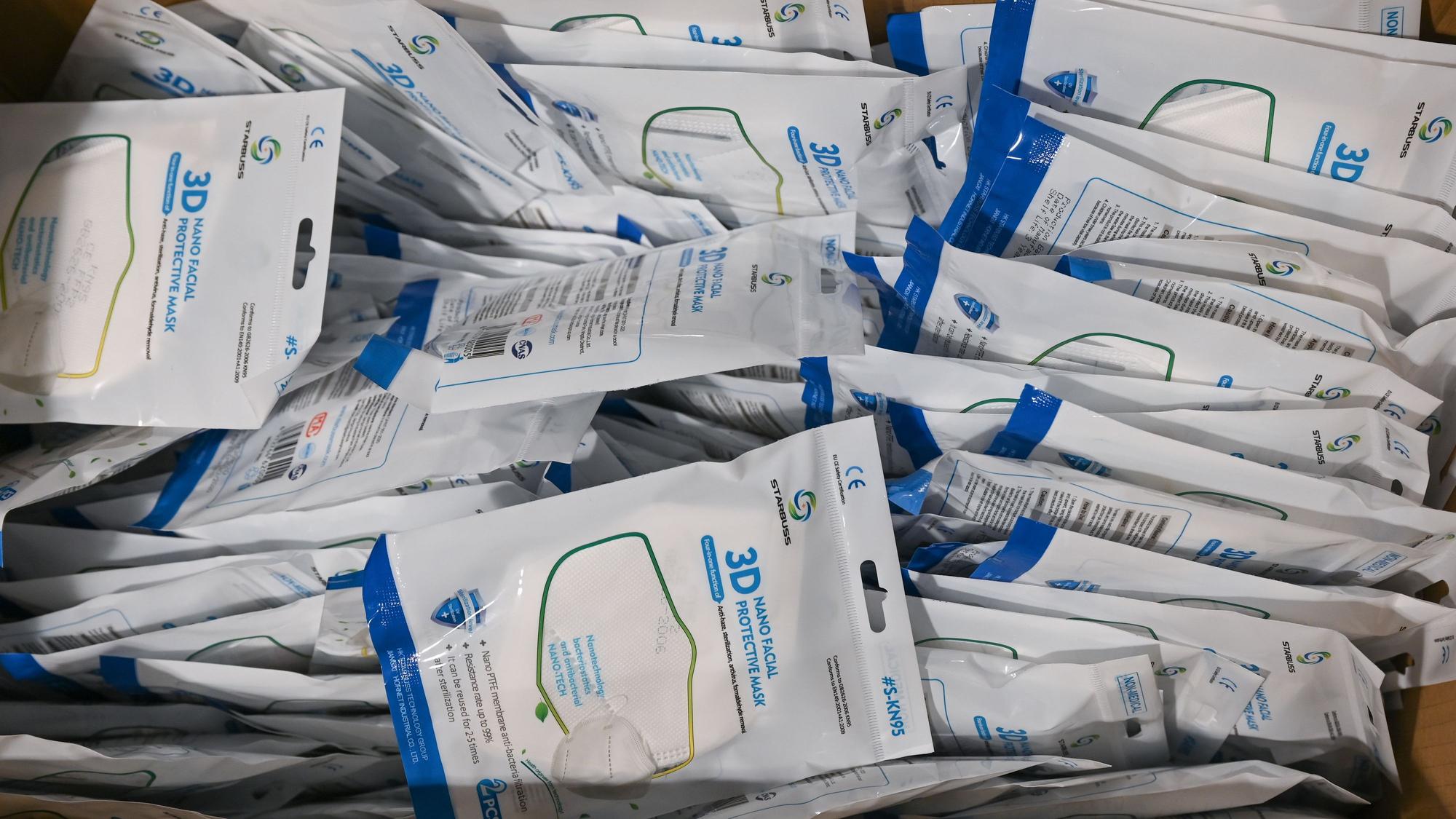 KN95-Masken liegen am Eingang eines Impfzentrum einzeln verpackt in einer Kiste. (Symbolbild)