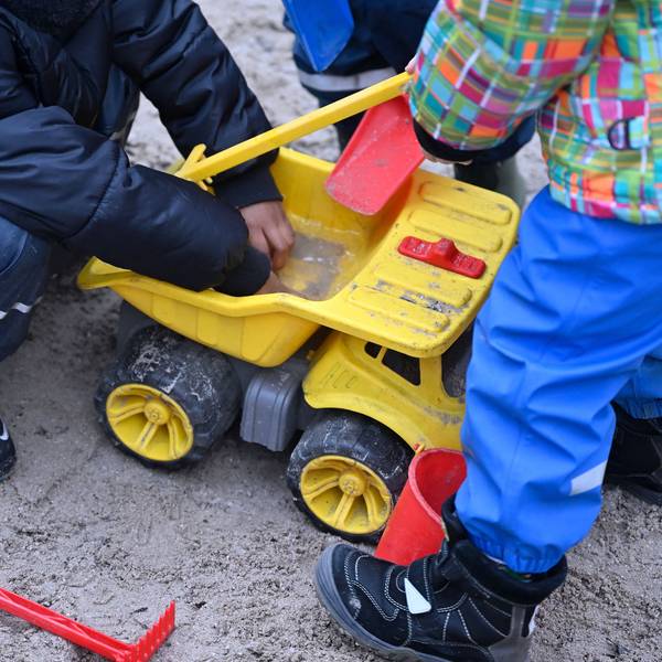Kinder spielen in einem Sandkasten.
