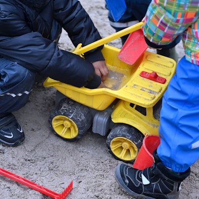 Kinder spielen im Sandkasten.