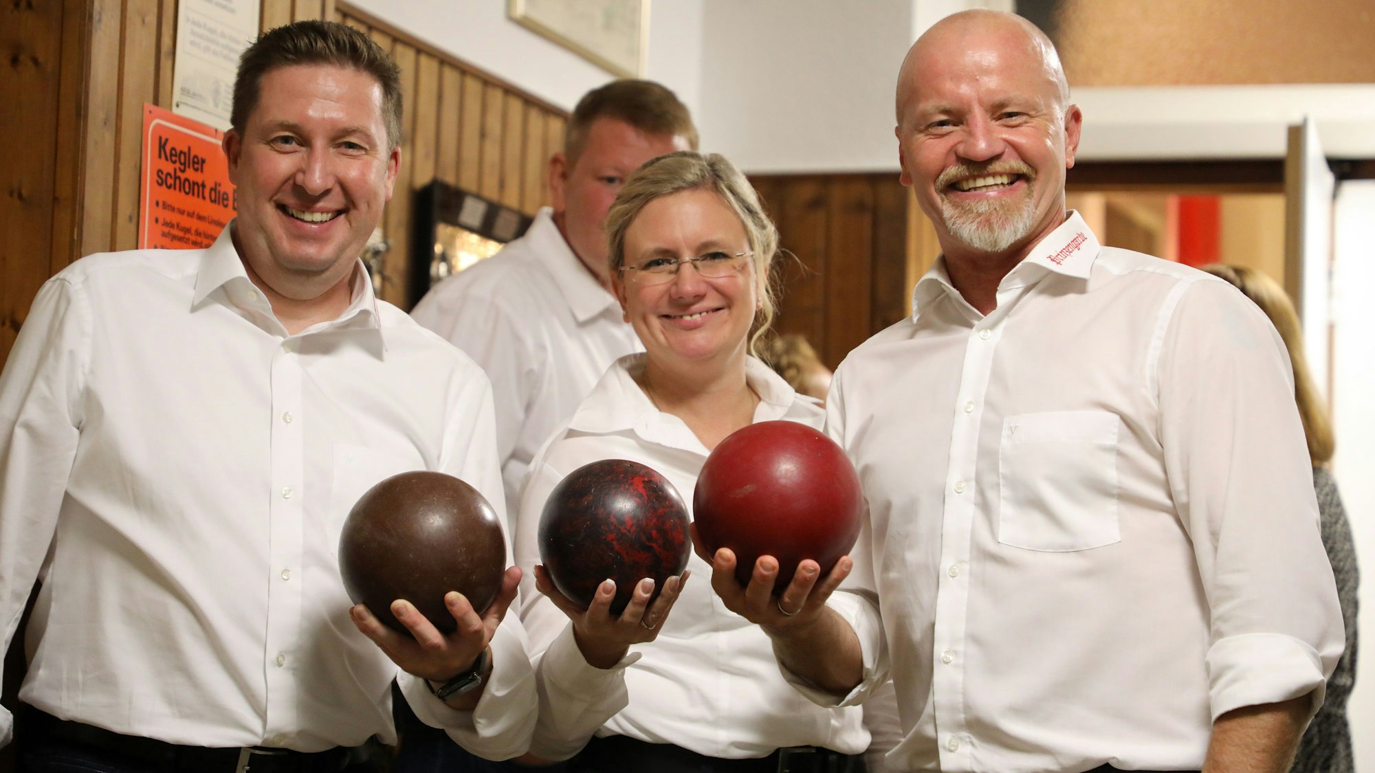 Das Dreigestirn mit Kegelkugeln in der Hand.