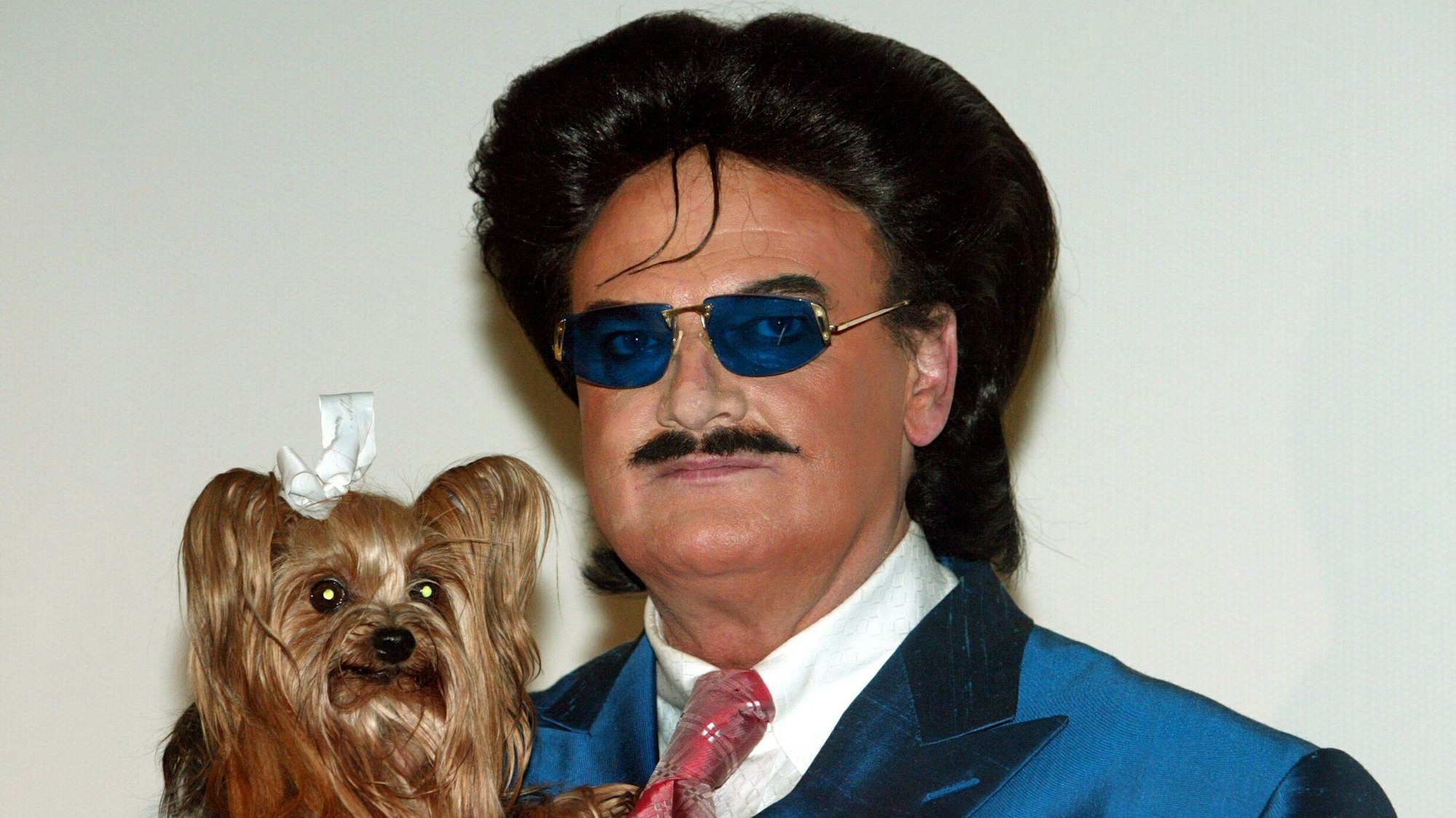 Der Modezar Rudolph Moshammer hält sein Hündchen ´Daisy» bei einer Pressekonferenz.