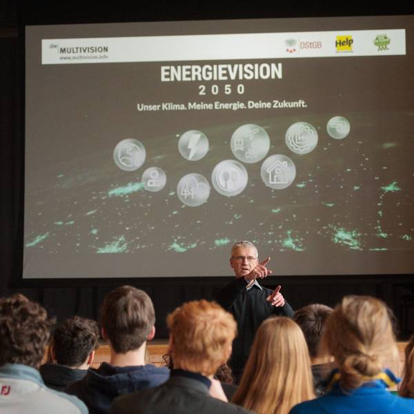 Der Biologe Stefan Simonis steht vor einer Leinwand. Vor ihm sitzen mehrere Schüler und Schülerinnen.