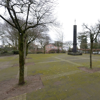 Der Deutsche Platz mit Bäumen und einem Denkmal.
