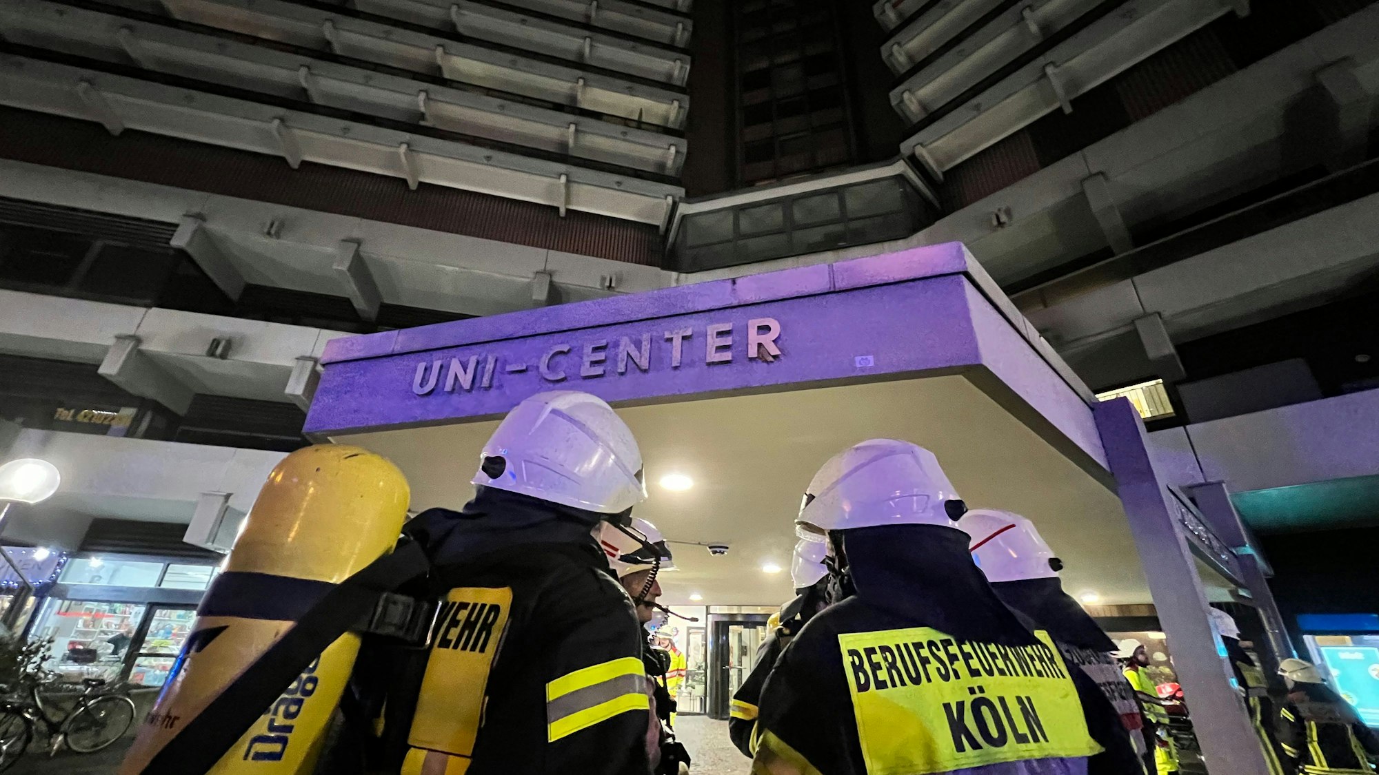 Einsatzkräfte der Kölner Feuerwehr vor dem Eingang des Uni-Center.