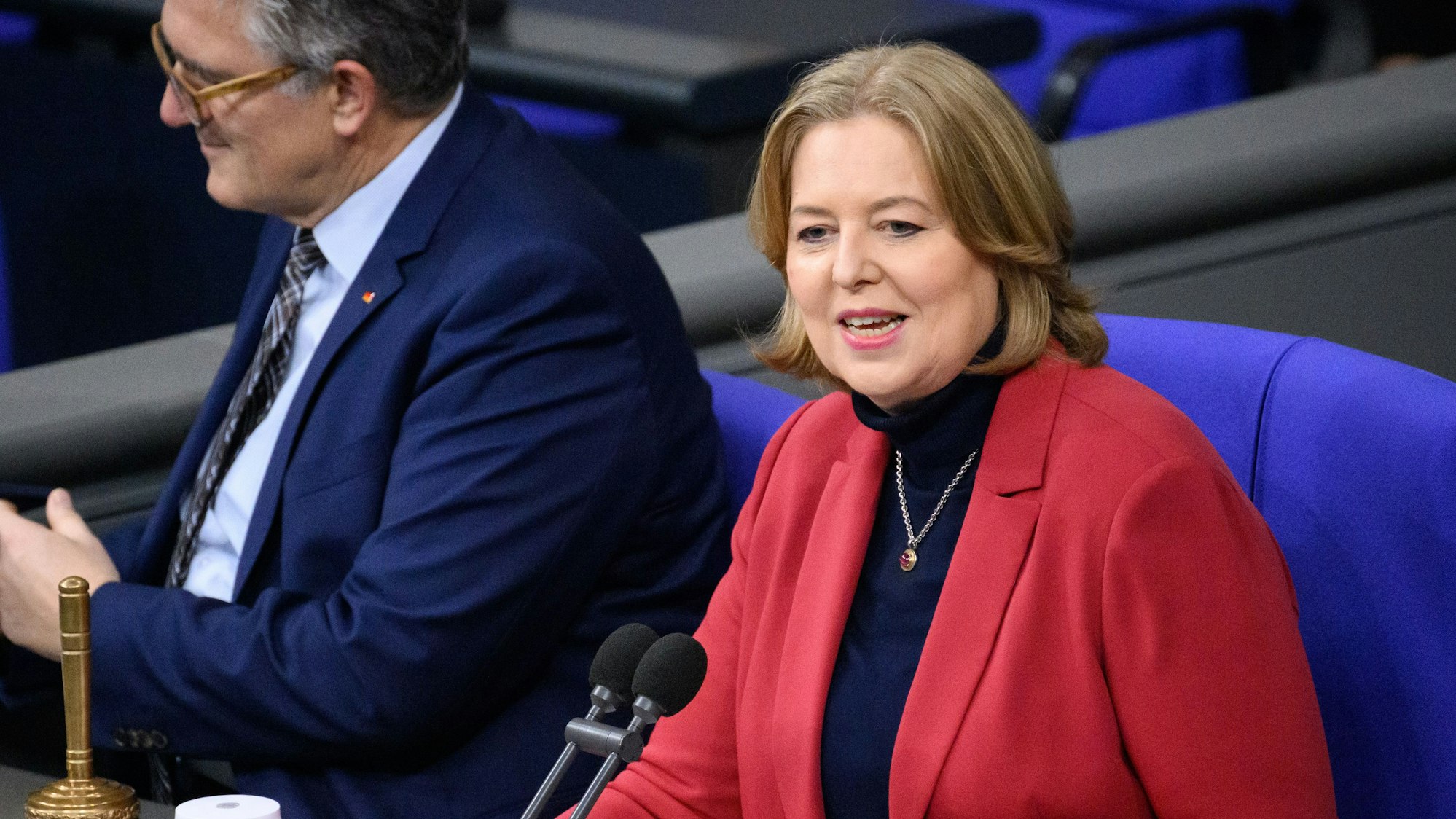 Bärbel Bas sitzt im Plenarsaal des Deutschen Bundestags vor einem Mikrofon.