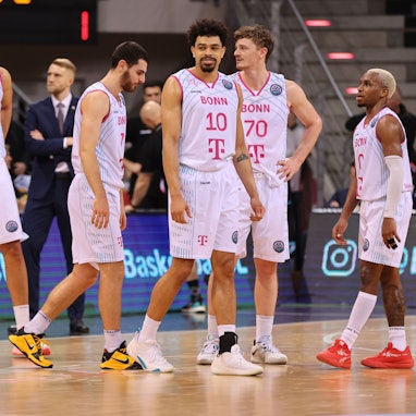 Mehrere Spieler der Telekom Baskets Bonn stehen auf dem Spielfeld.