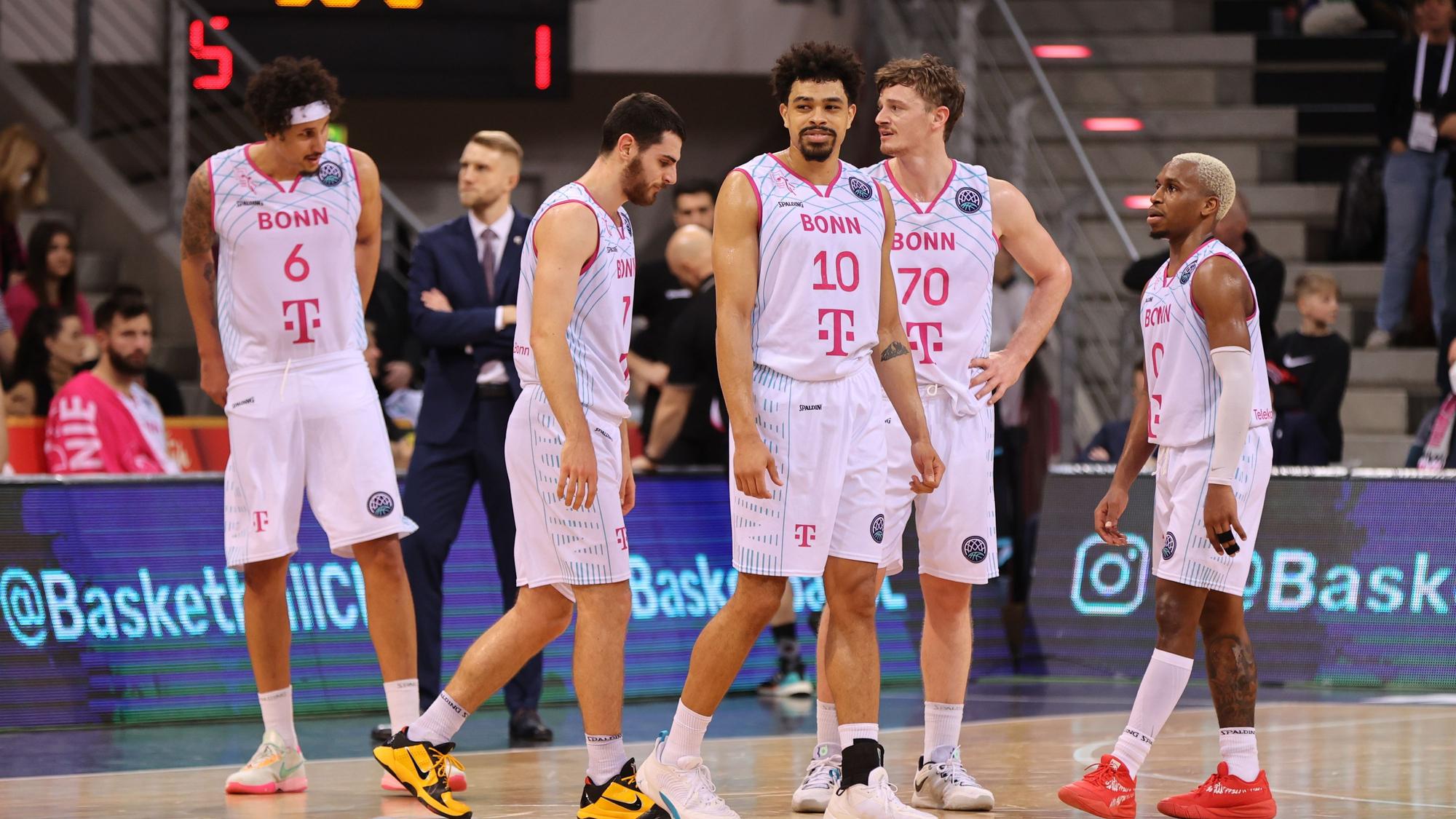 Mehrere Spieler der Telekom Baskets Bonn stehen auf dem Spielfeld.